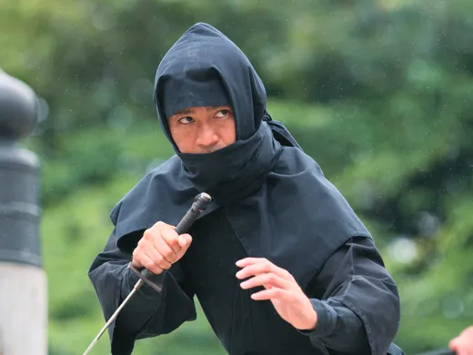 Ein Mann im schwarzen Ninja-Gewand mit Schwert